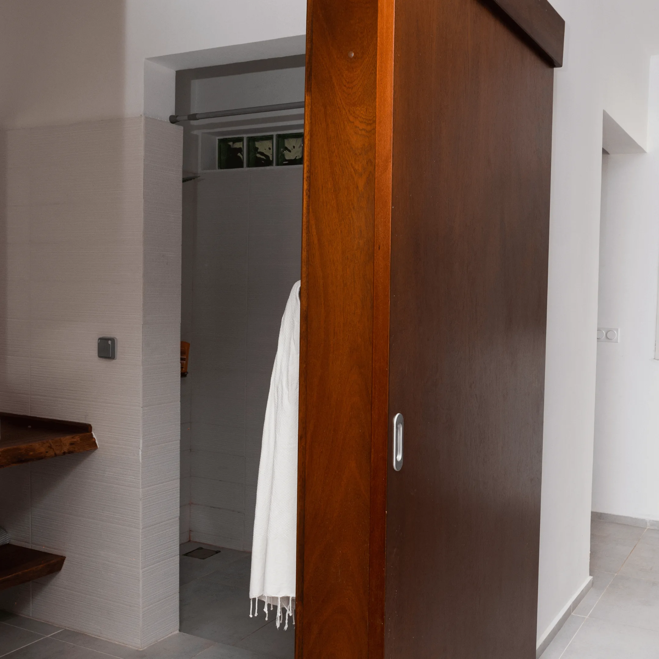 Porte coulissante bois massif - Projetti Porte coulissante en bois massif pour salle de bain, menuiserie bois Côte d'Ivoire.